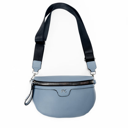 Miss Caprice Waist/Crossbody Bag in denim blue with adjustable black nylon strap for convenient hands-free style, front view.