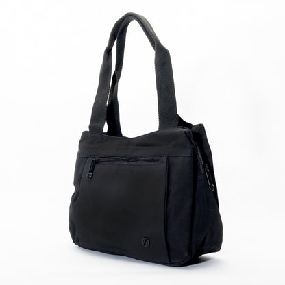 The Miss Caprice Nylon Shoulder Bag Tote is a black, lightweight bag with two straps and a front zip pocket.