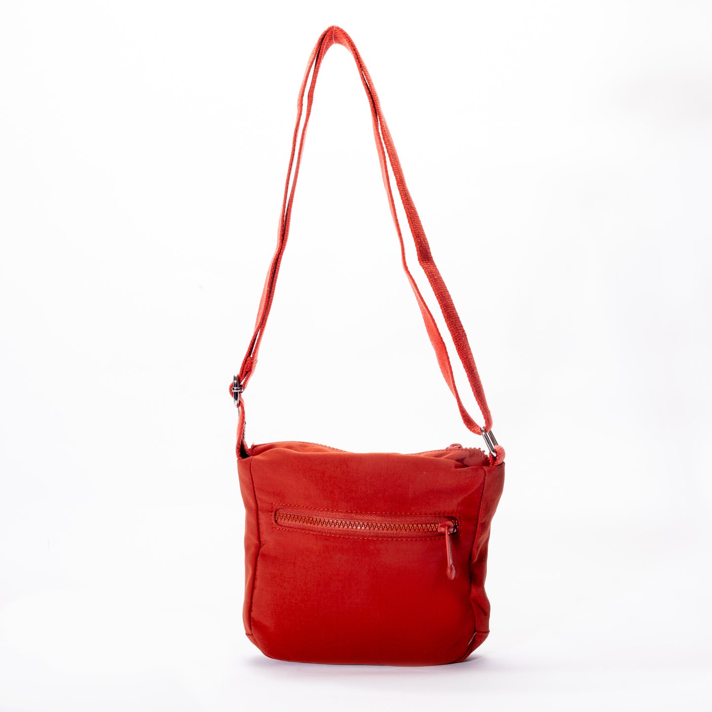 The Miss Caprice Small Nylon Crossbody is a red bag with a zip pocket and adjustable strap, ideal for travel.