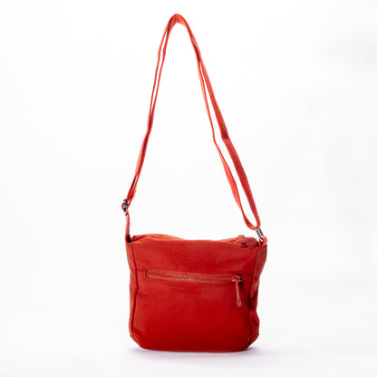 The Miss Caprice Small Nylon Crossbody is a red bag with a zip pocket and adjustable strap, ideal for travel.