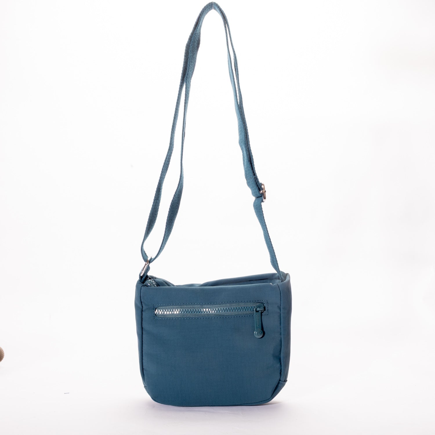 The Miss Caprice Small Nylon Crossbody is a blue bag with zip pocket and adjustable strap, ideal for travel.