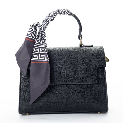 Miss Caprice Hope Handbag in black faux leather, adorned with a patterned scarf, shown on a white background.