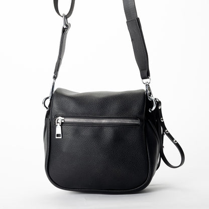 Miss Caprice Clara Crossbody bag in black faux leather, with zip pockets and adjustable strap, shown on white.