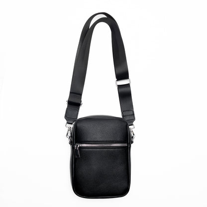 Miss Caprice Compact Crossbody: a black leather bag with front zip pocket and adjustable strap for travel.
