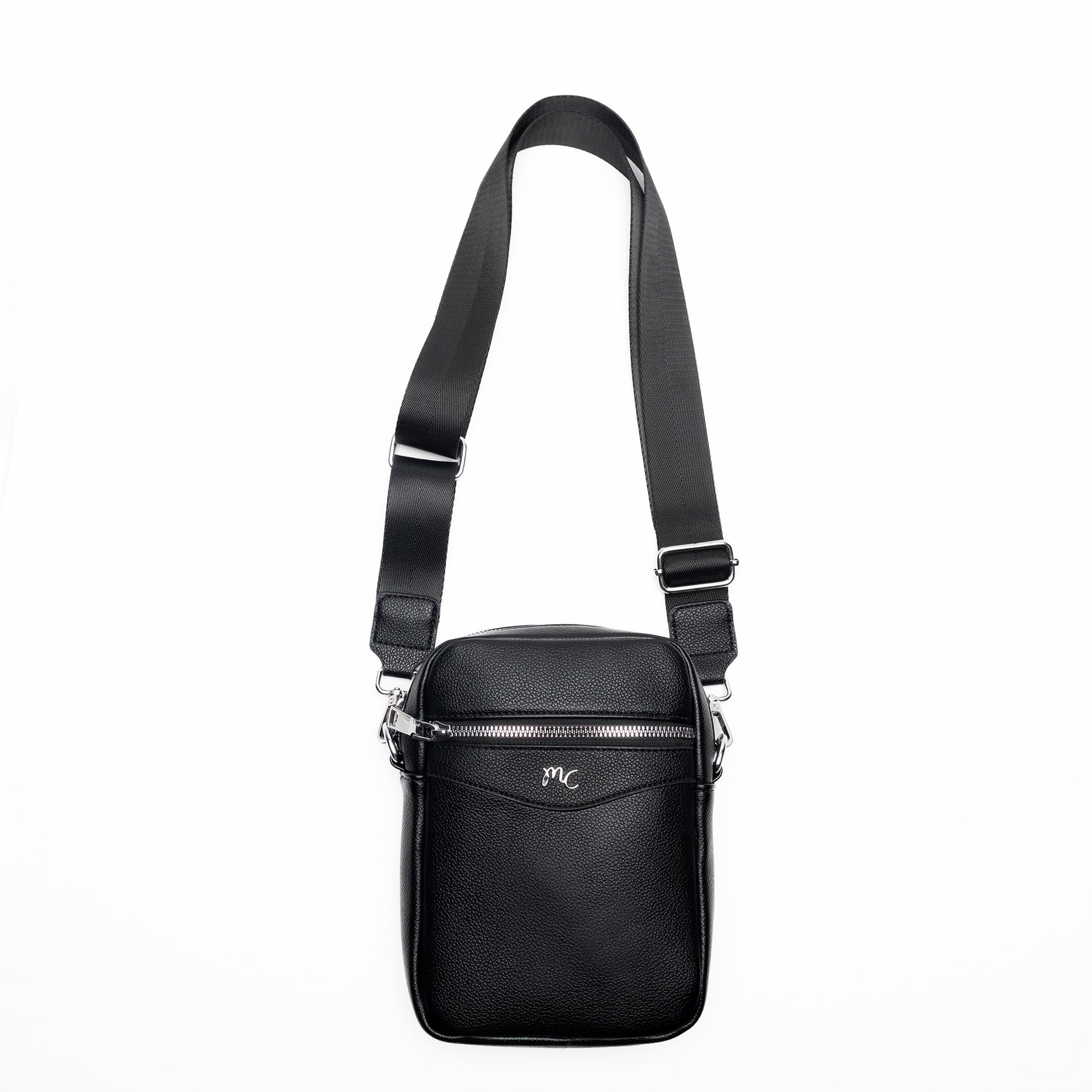 The Miss Caprice Compact Crossbody is a black leather bag with a wide strap and front pocket, shown on white.