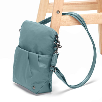 Pacsafe® CX Anti-Theft Convertible Crossbody, fresh mint, with strap attached through a chair leg