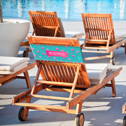 Lifestyle image of pink flamingo K5 Reserved Chair Sleeve, placed on a poolside chair.