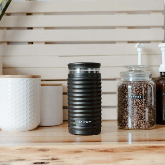 Product Image – Matte black Grosche Bremen electric blade coffee grinder with ribbed texture on wooden counter