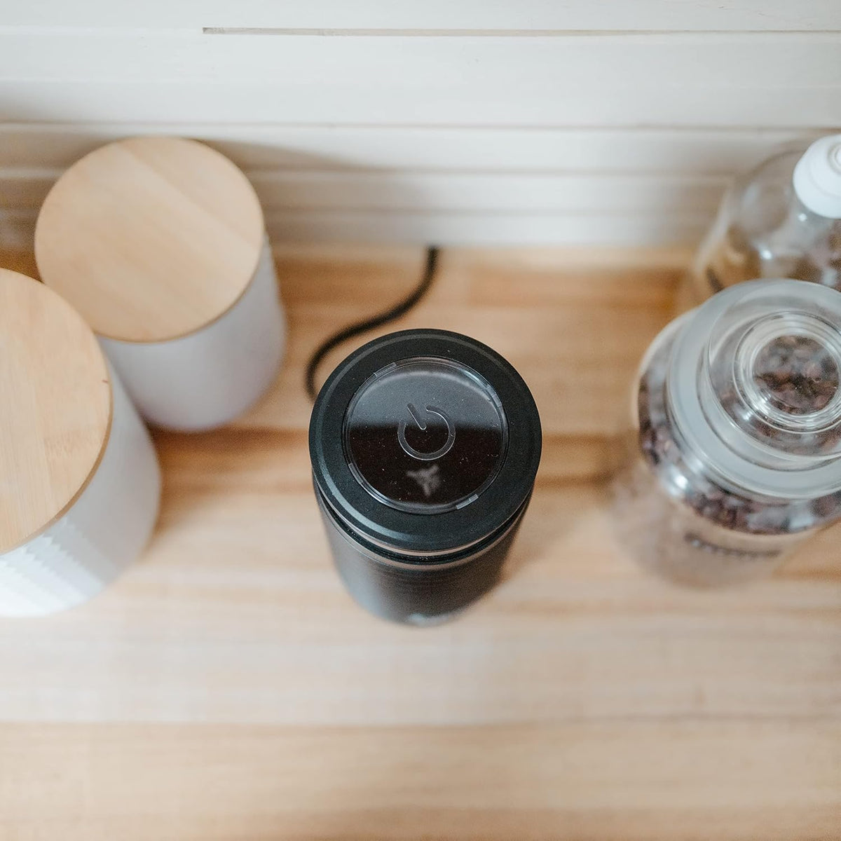 Top view of Grosche electric blade coffee grinder showing clear lid and power button symbol