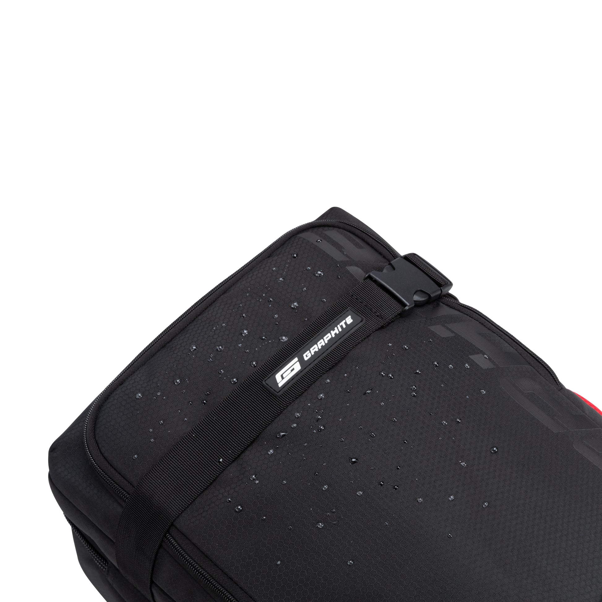 A close-up of the Graphite Metamorph 21" Carry-on Wheeled Duffle in black, featuring a strap and water droplets on its water-resistant surface, making it ideal for outdoor adventures.