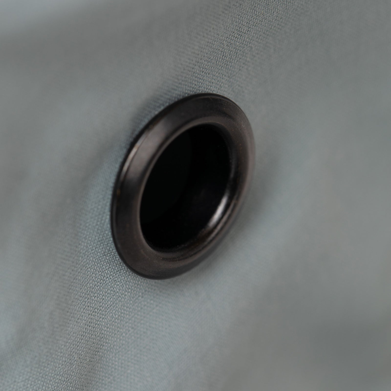 Close-up of a black metal grommet on Tilley T5 Adventure Ultralight Hat's gray UPF 50+ fabric.
