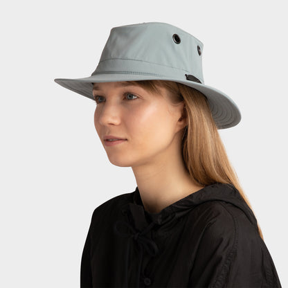 A woman in a Tilley T5 Adventure Ultralight Hat, wide-brimmed with UPF 50+, faces left against a plain background.