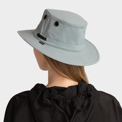 Person in a Tilley T5 Adventure Ultralight Hat and black jacket, shown from the back on a plain background.