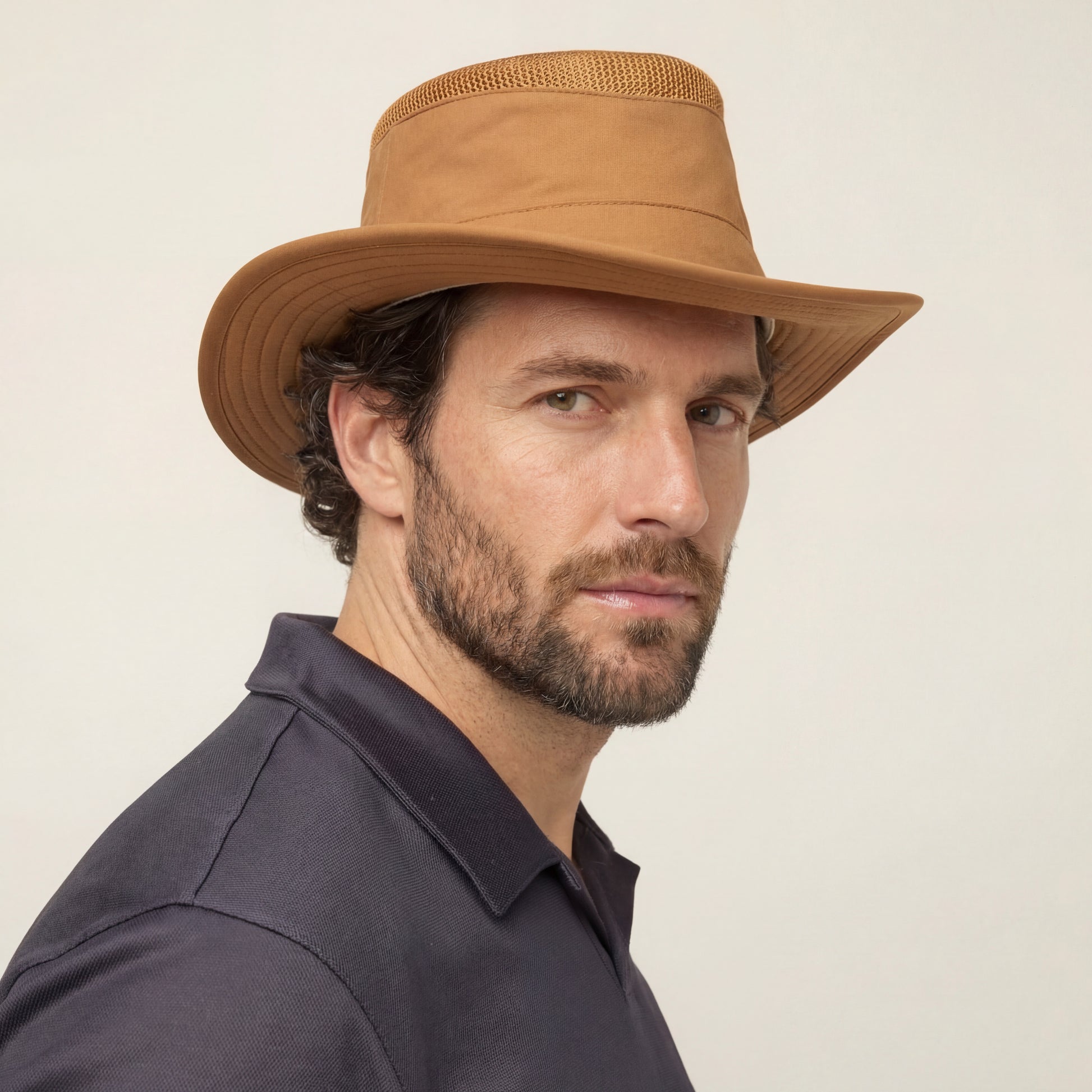 Bearded man in a Tilley LTM5 Airflo® Hat by Tilley and dark collared shirt, looking at the camera.