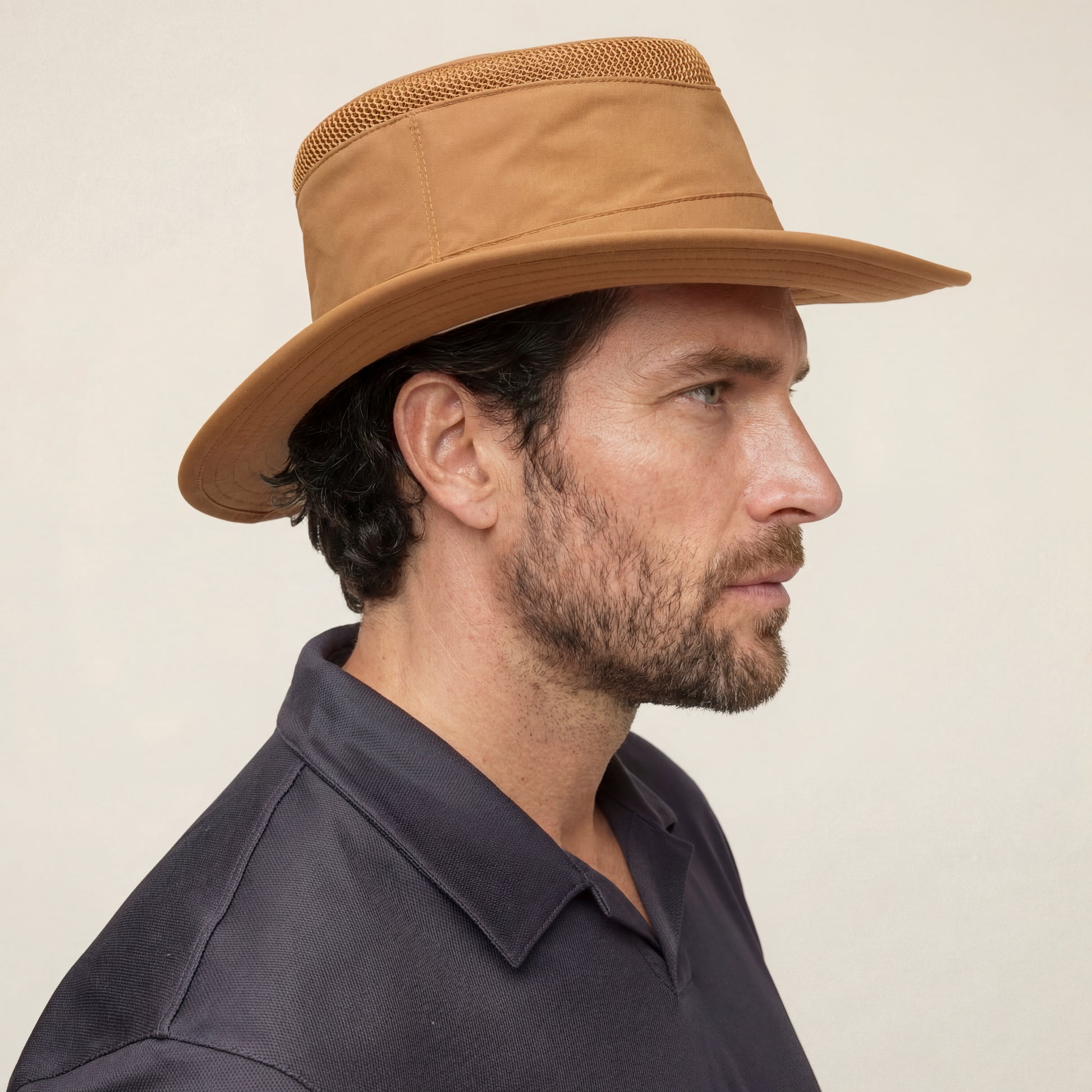 Man in profile wearing a Tilley LTM5 Airflo® Hat by Tilley, featuring mesh ventilation, against plain background.