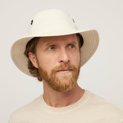 A bearded man in a Tilley T5 Adventure Ultralight Hat and beige shirt enjoys UPF 50+ sun protection.