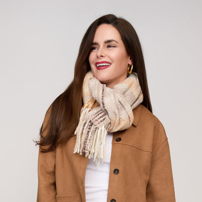 Woman wearing a buttery soft, taupe and cream Howard’s Taupe Plaid Fringe Scarf - ONLINE ONLY with fringe.