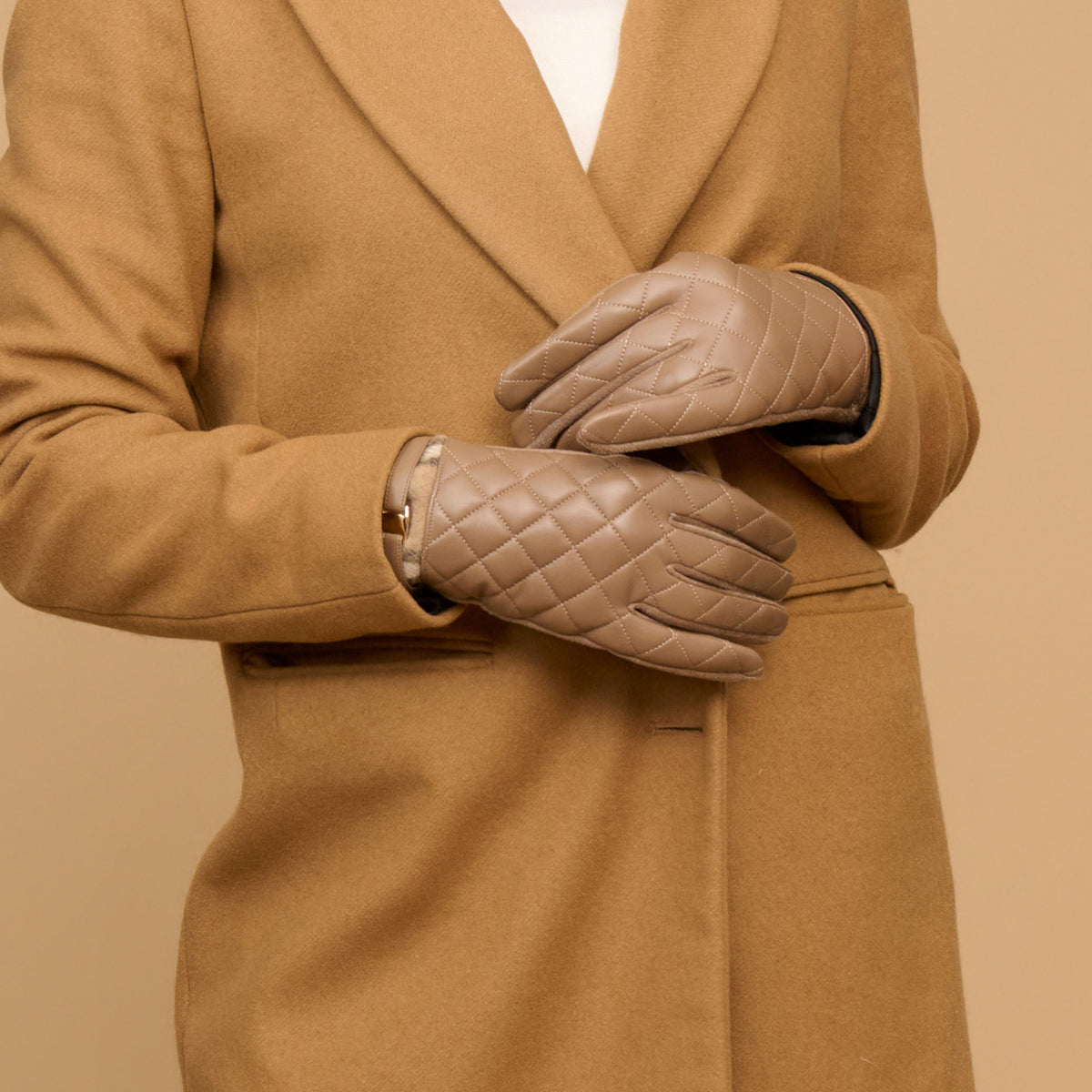 Howard’s Vivi Quilted Vegan Leather Gloves in taupe, paired with a tan coat.