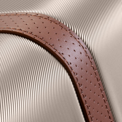 Close-up of perforated brown leather strap on Ricardo Beverly Hills Montecito 2.0 25" hardside expandable spinner.