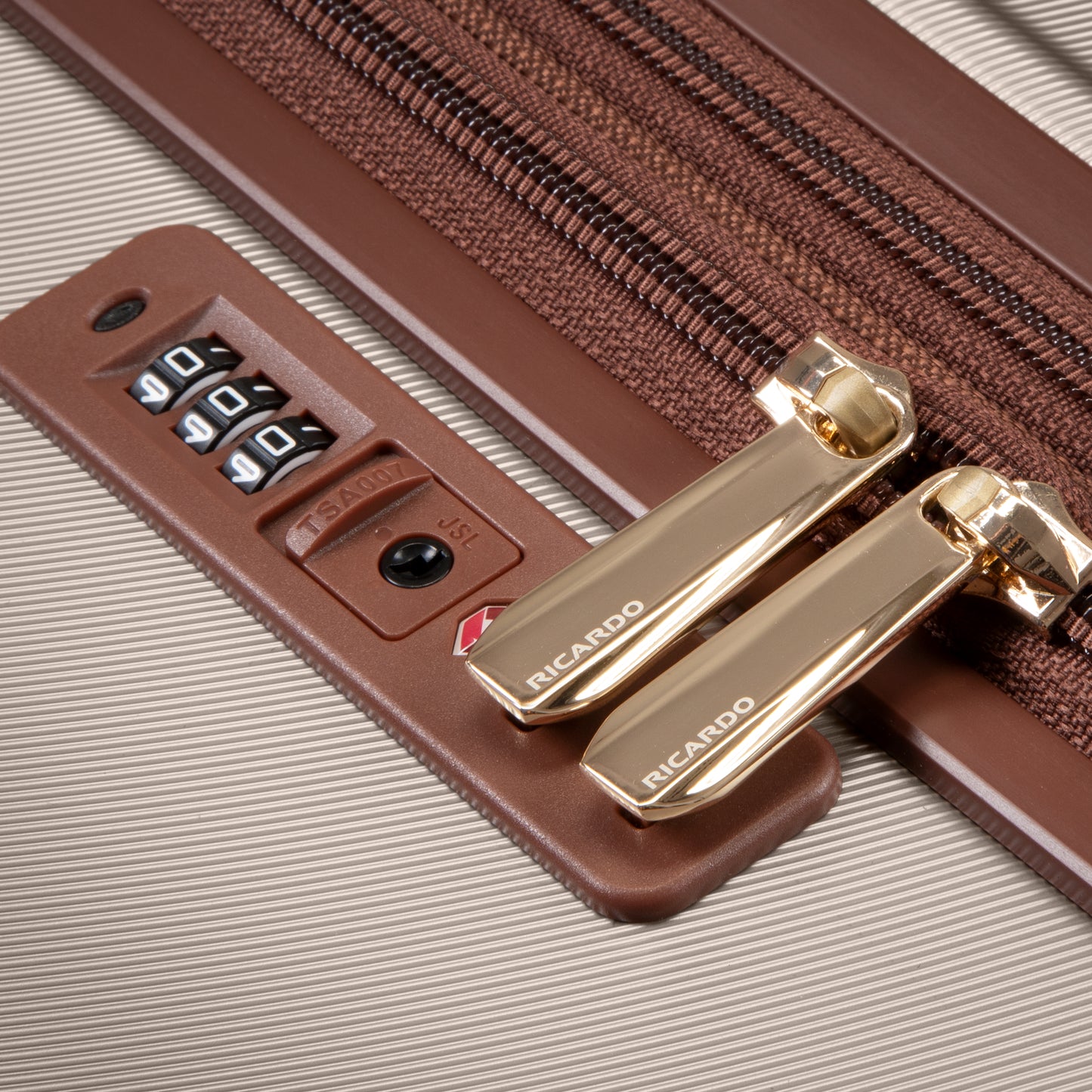 Close-up of gold zippers in a TSA lock on Ricardo Beverly Hills Montecito 2.0 25" Hardside Spinner luggage.