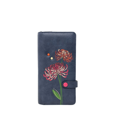 The Espe Mae Clutch Wallet is a navy vegan wallet with red and pink floral embossing and a pink snap closure.