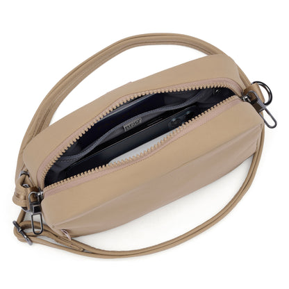 Pacsafe® CX Anti-theft Square Crossbody by Pacsafe with zipper open, smartphone, dark lining, and RFIDsafe pockets.