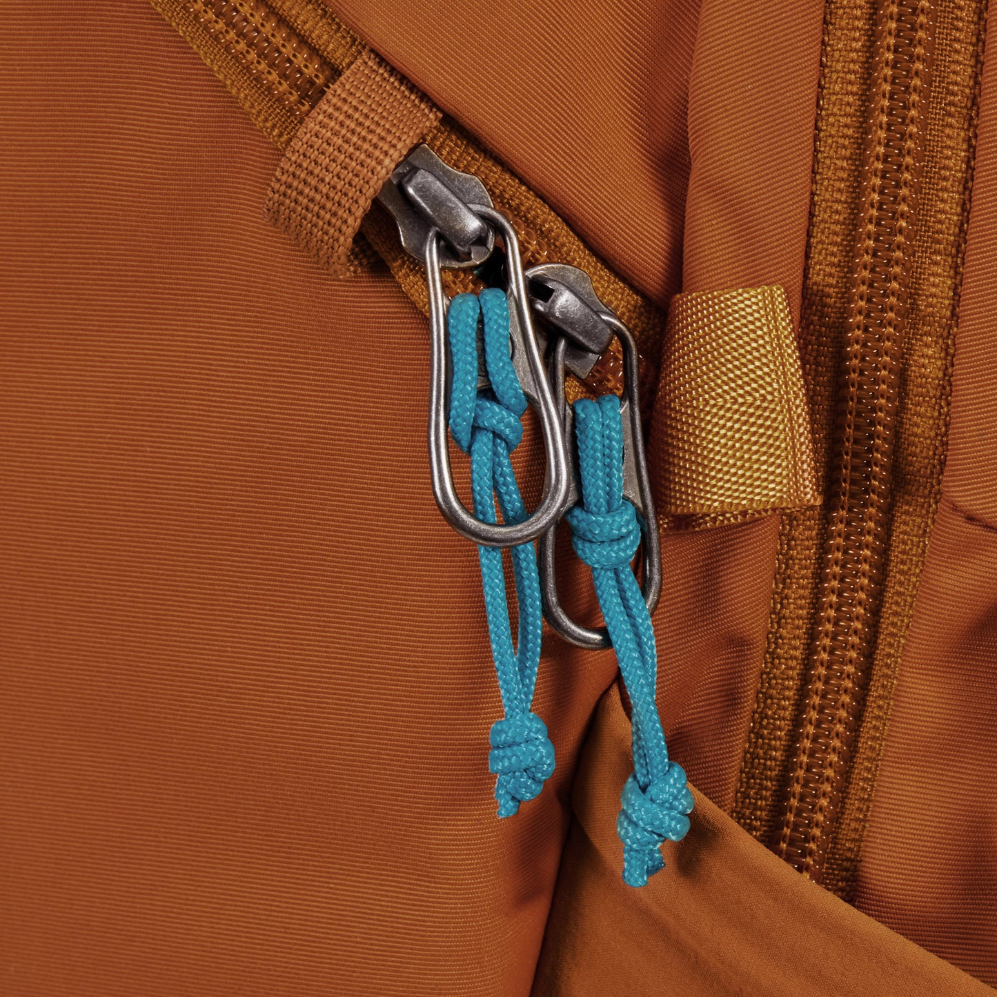 Close up of zipper pulls on canyon Pacsafe® ECO 18L Anti-theft Backpack