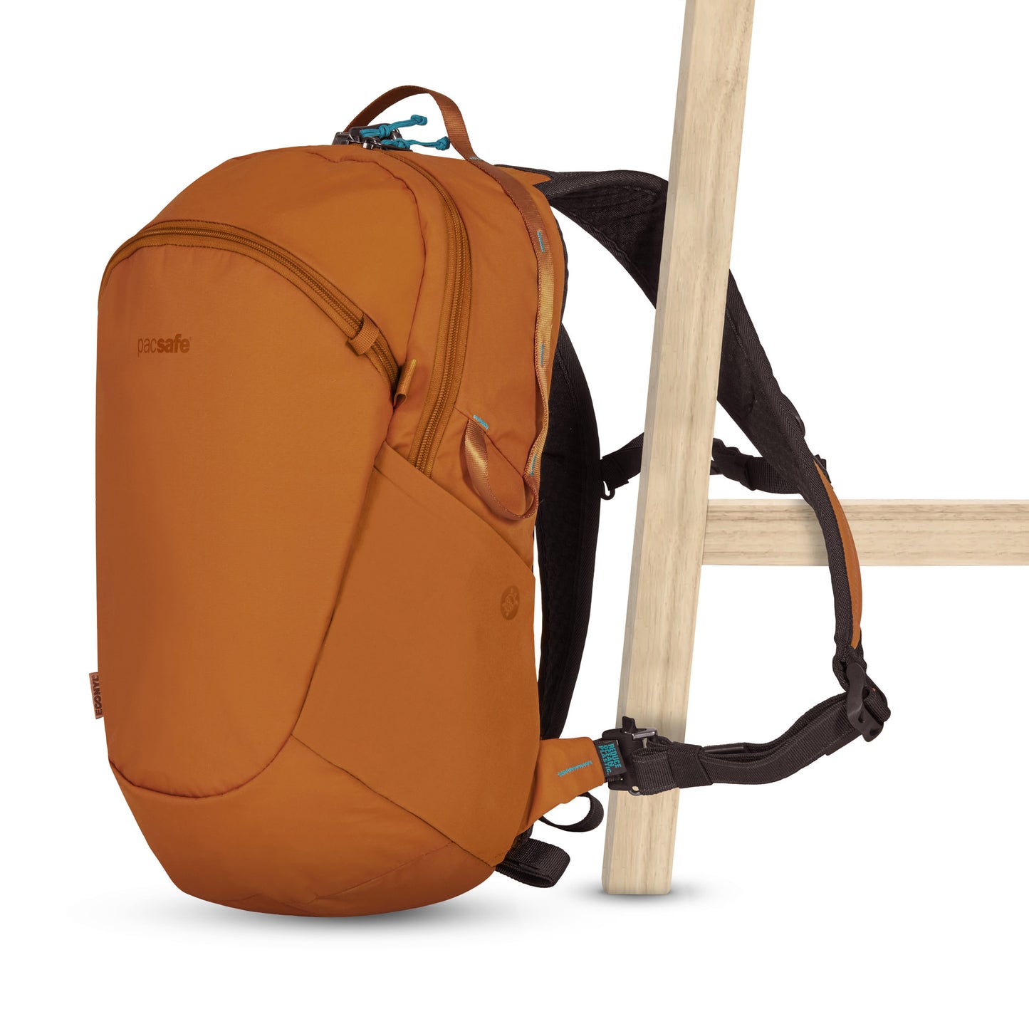 Pacsafe® ECO 18L Anti-theft Backpack, canyon orange colour, with one shoulder strap secured to a chair leg