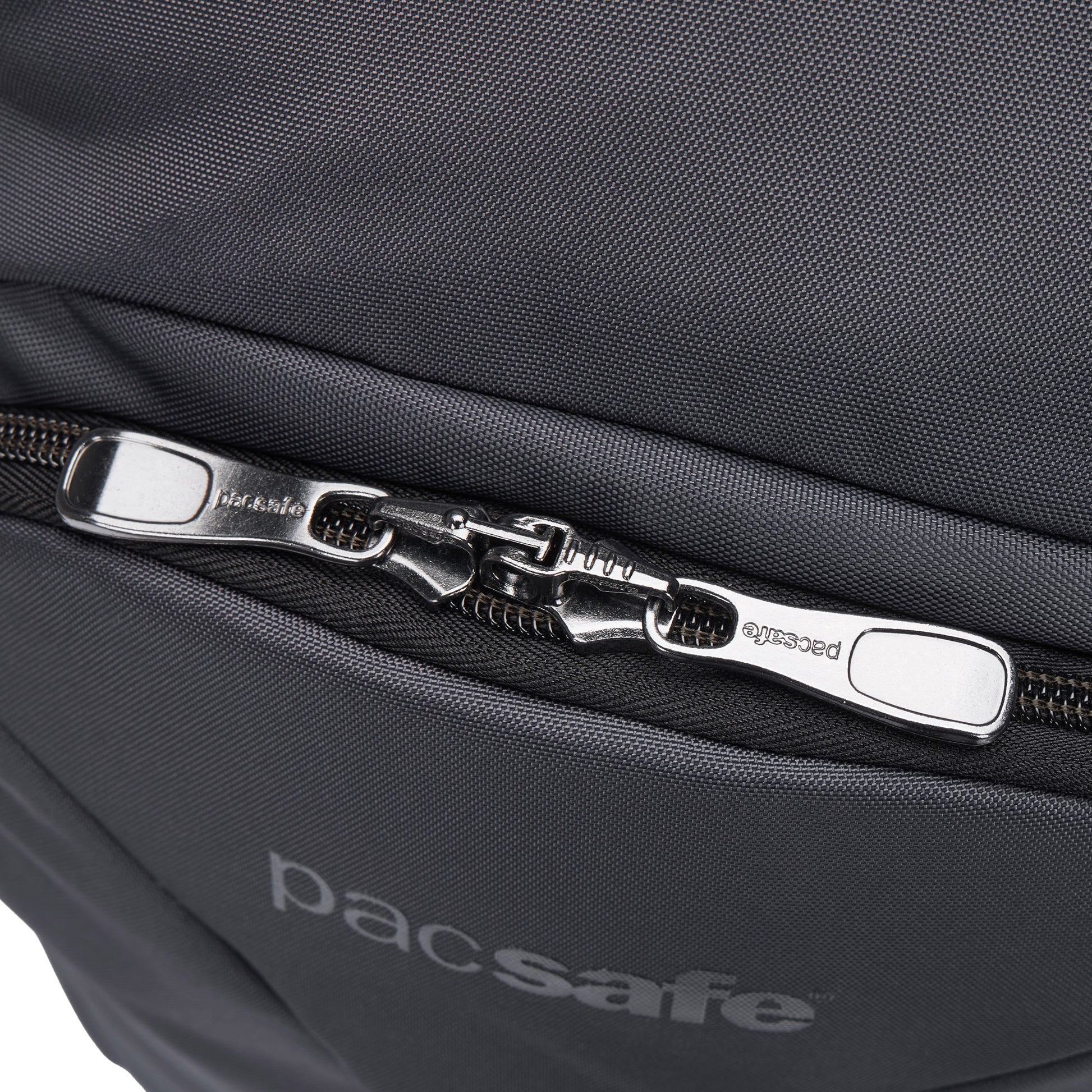 Close-up of Pacsafe® EXP 28L Anti-Theft Backpack showing dual interlocked zippers and Pacsafe branding below.