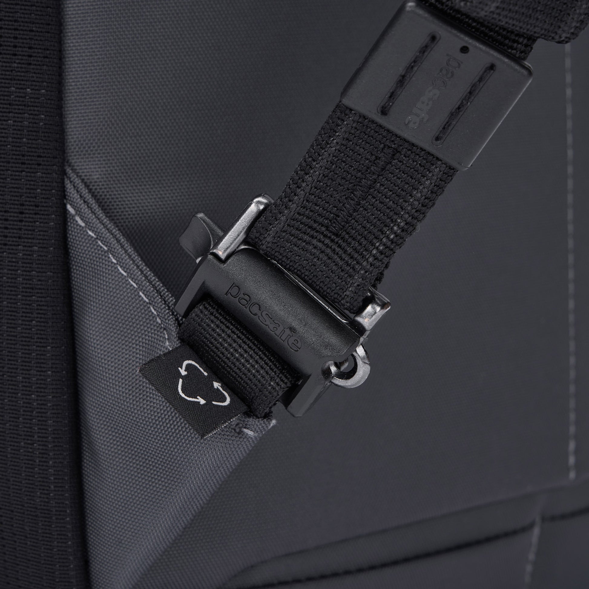 Close-up of a Pacsafe® EXP 28L Anti-Theft Backpack strap with a plastic buckle and visible stitching.