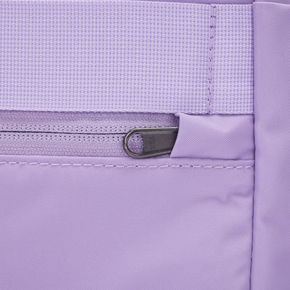 Close-up of Pacsafe® GO 15L Anti-theft Backpack's lavender pocket with zipper, waistband, and RFID block.