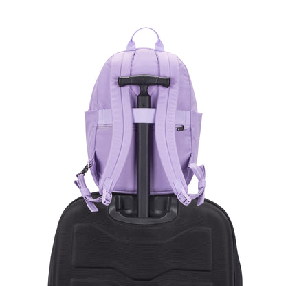 A Pacsafe® GO 15L Anti-theft Backpack in lavender is secured to a black rolling suitcase handle.