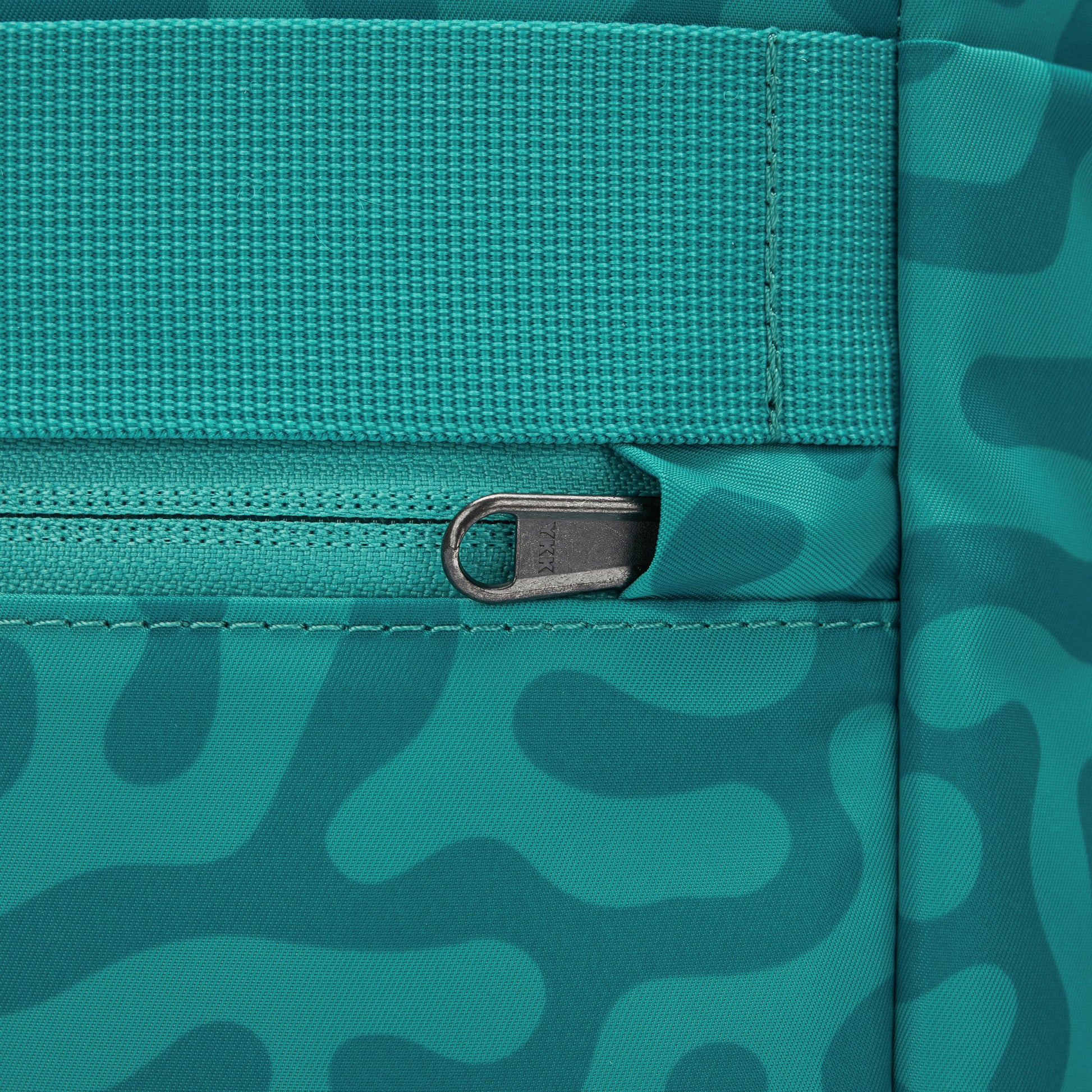 Close up of security pocket on back with tucked zipper pull for added security.
