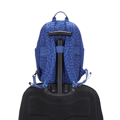 Pacsafe® GO 15L Anti-theft Backpack by Pacsafe, blue patterned, sits on a black suitcase with white background.