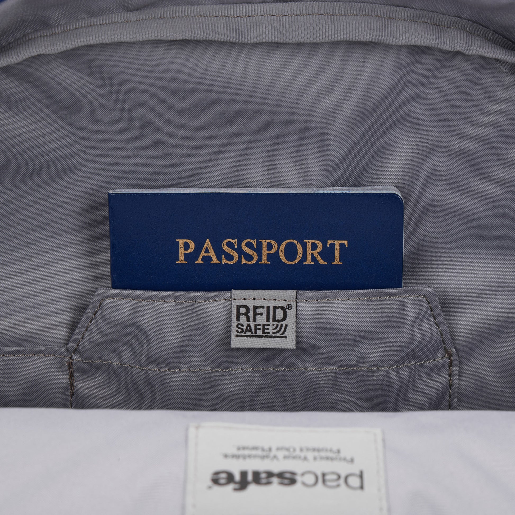 A blue passport in an RFID pocket inside the gray Pacsafe® GO 15L Anti-theft Backpack.