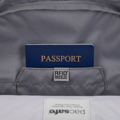 A blue passport in an RFID pocket inside the gray Pacsafe® GO 15L Anti-theft Backpack.