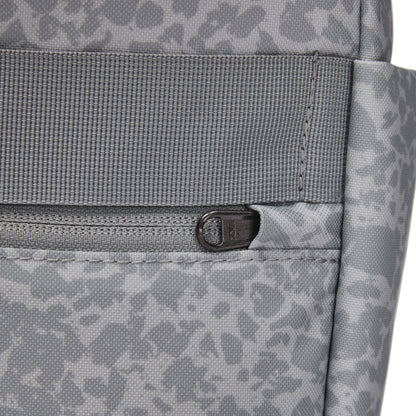 Close-up of Pacsafe® GO 15L Anti-theft Backpack in gray recycled polyester with front zipper and abstract pattern.