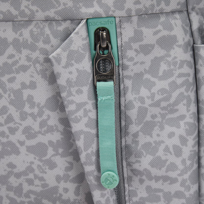 Close-up of a Pacsafe® GO 15L Anti-theft Backpack pocket with zipper and teal Pacsafe pull.