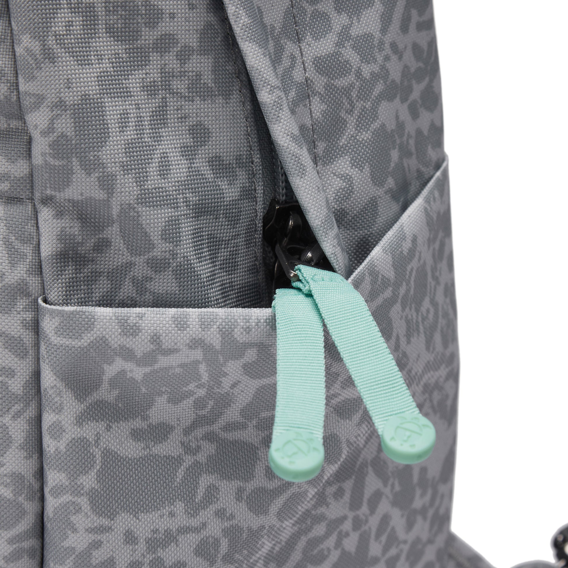 Close-up of the Pacsafe® GO 15L Anti-theft Backpack in gray with turquoise pulls and RFID blocking.