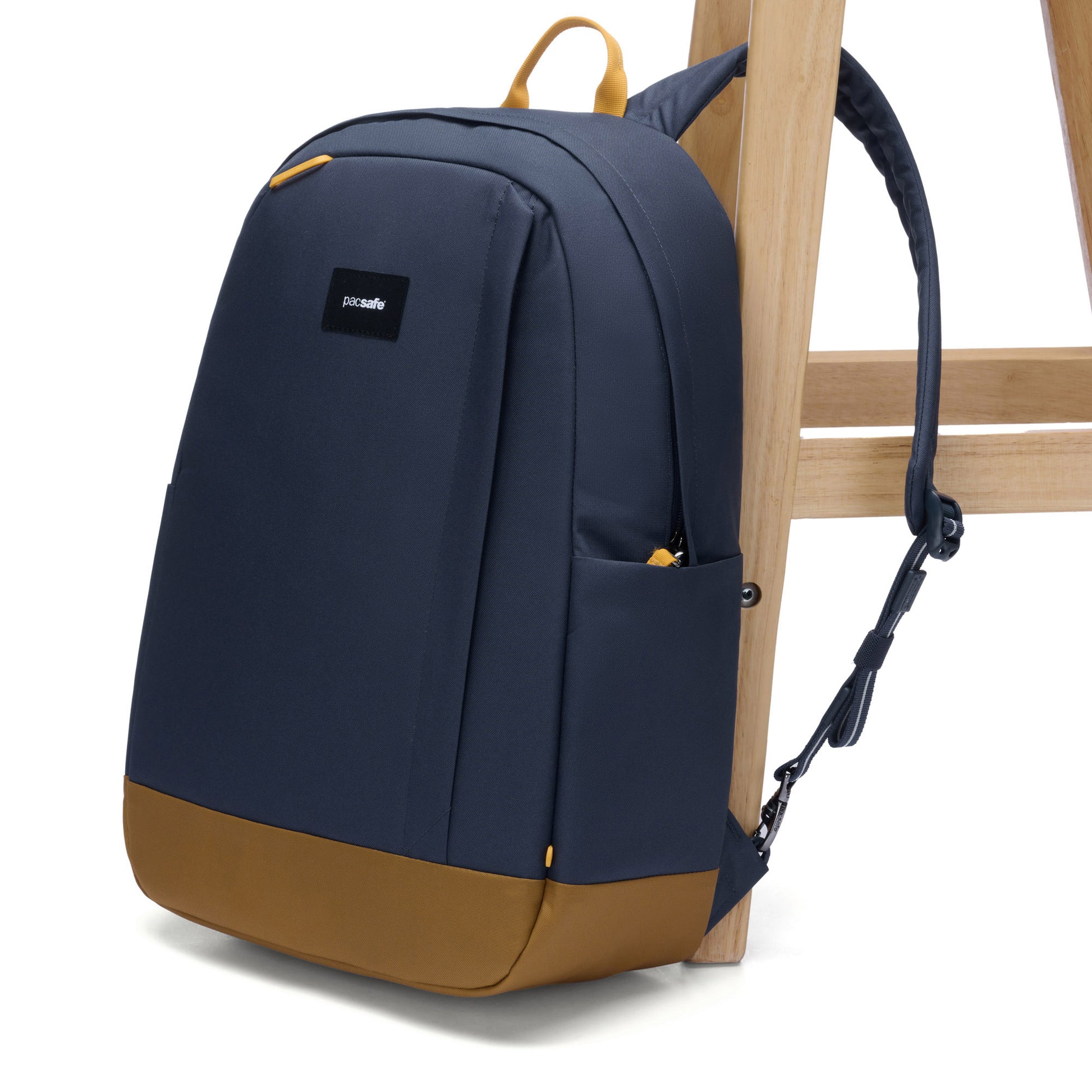 Pacsafe® GO 25L Anti-theft Backpack, coastal blue, attached to wooden chair leg.