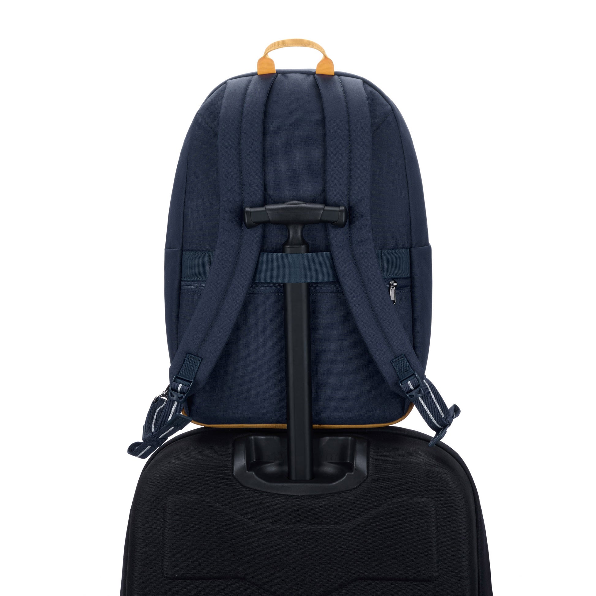 Pacsafe® Go 25L Anti-theft Backpack, coastal blue, back view sitting on top of a black luggage with handle through back strap