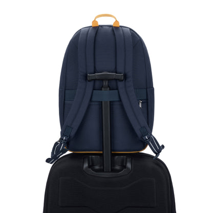 Pacsafe® Go 25L Anti-theft Backpack, coastal blue, back view sitting on top of a black luggage with handle through back strap