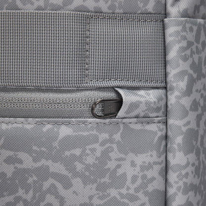 Close-up of Pacsafe® GO 25L Anti-theft Backpack in gray, with a zipper pocket and abstract pattern on fabric.