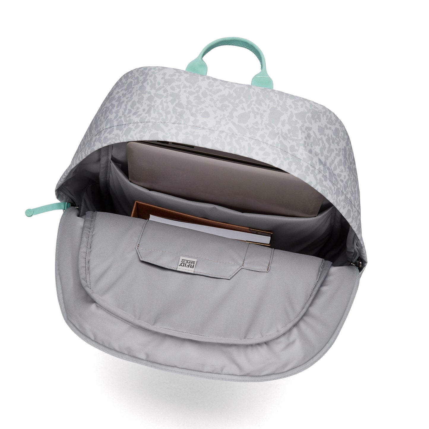 Open Pacsafe® GO 25L Backpack with a laptop and notebooks inside, showing organized compartments.