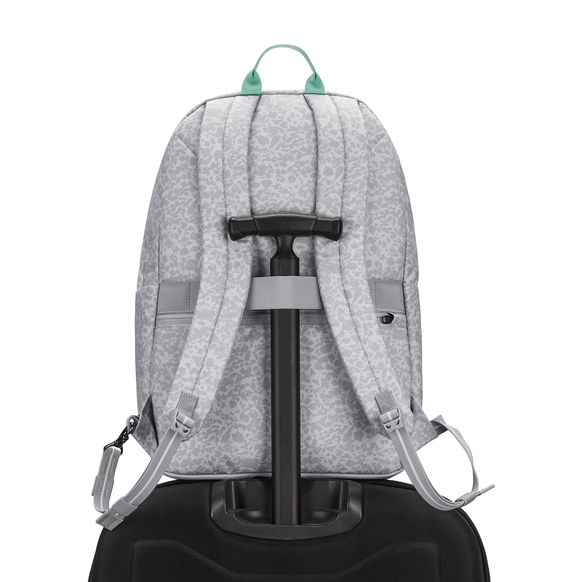 Pacsafe® GO 25L Anti-theft Backpack in gray sits on a black suitcase, viewed from the back.
