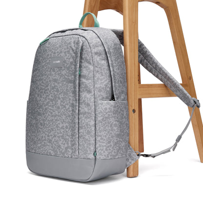 Pacsafe® GO 25L Anti-theft Backpack rests on a stool, one strap secured around a wooden leg.