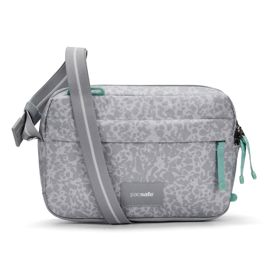 Product Image – Pacsafe® GO Anti-Theft Crossbody Bag in light gray with green zippers, front pocket, and recycled polyester.