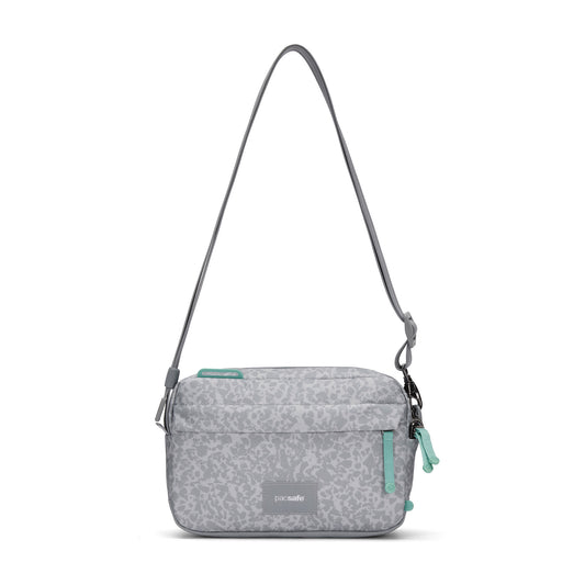 Product Image – Pacsafe® GO Anti-Theft Crossbody Bag in light gray with green zippers, recycled polyester, on white background.
