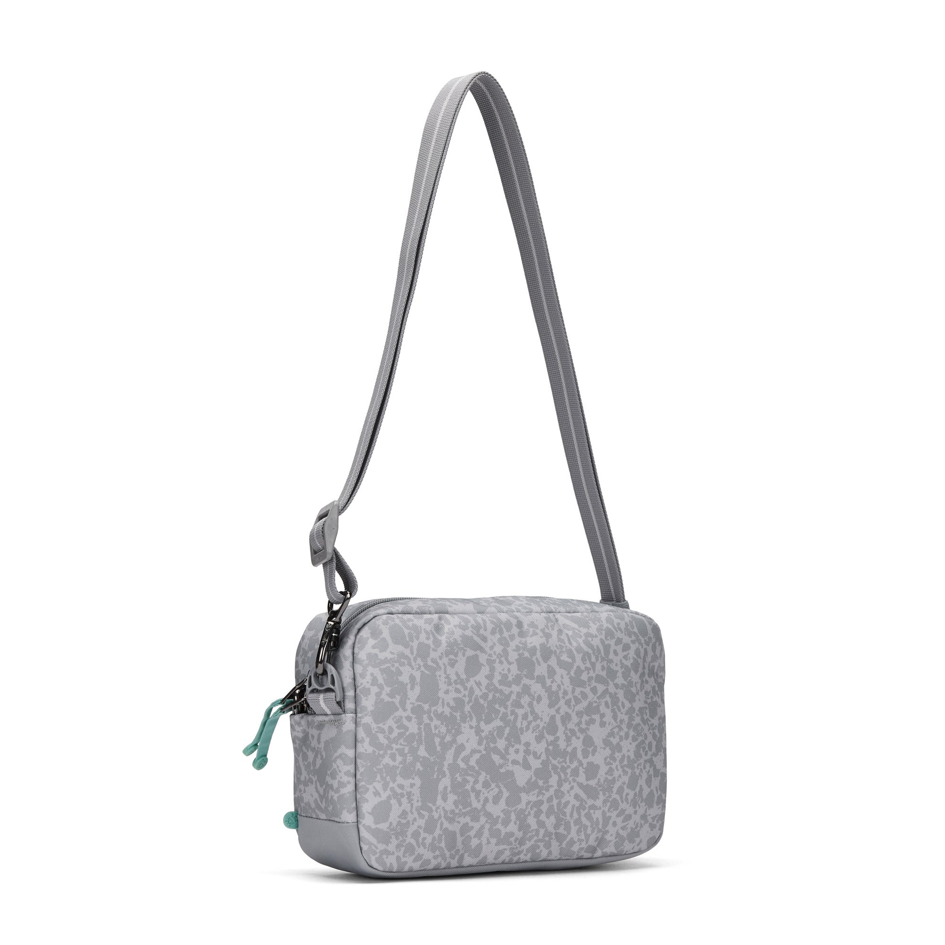 Pacsafe® GO Anti-Theft Crossbody Bag in light gray recycled polyester with abstract pattern, adjustable strap.