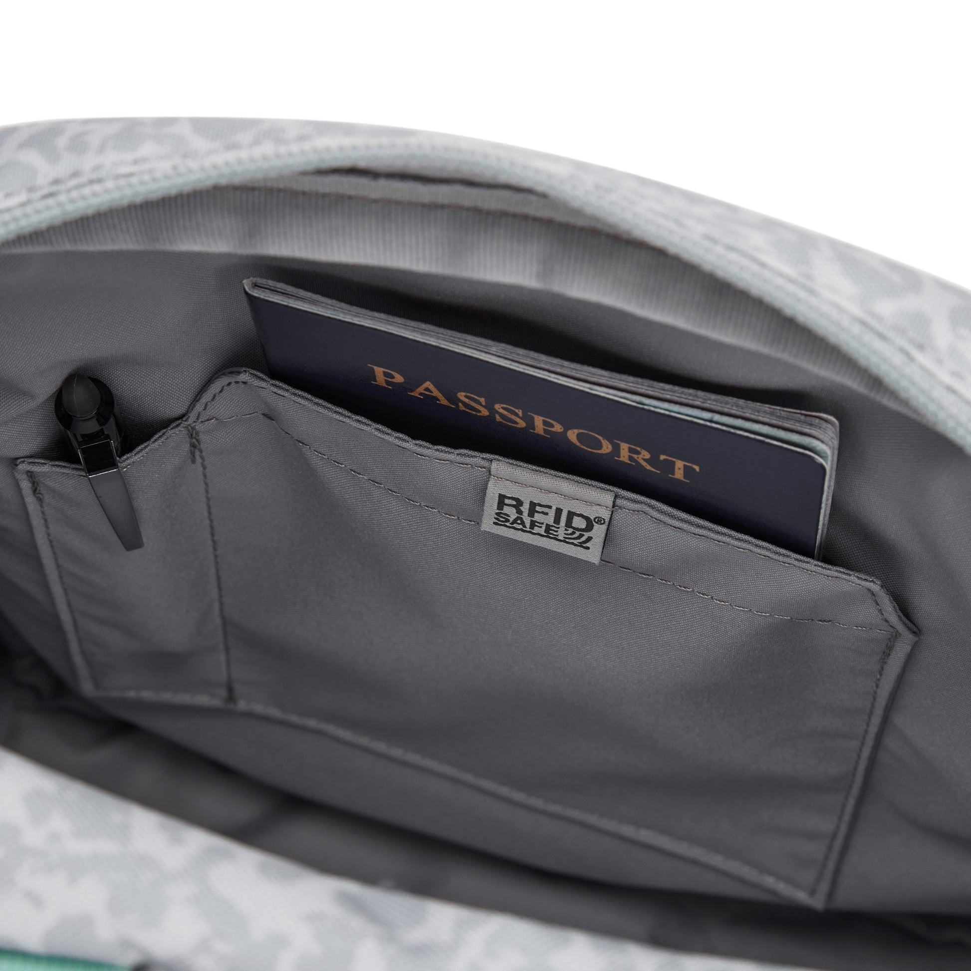 Close-up of Pacsafe® GO Anti-Theft Crossbody Bag with RFID pocket, holding a passport and RFID Safe pouch.